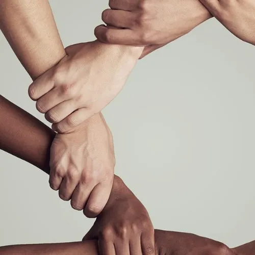 Een groep handen die elkaar vasthouden