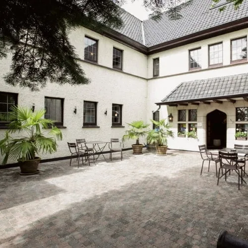 A patio with chairs and tables in front of a building